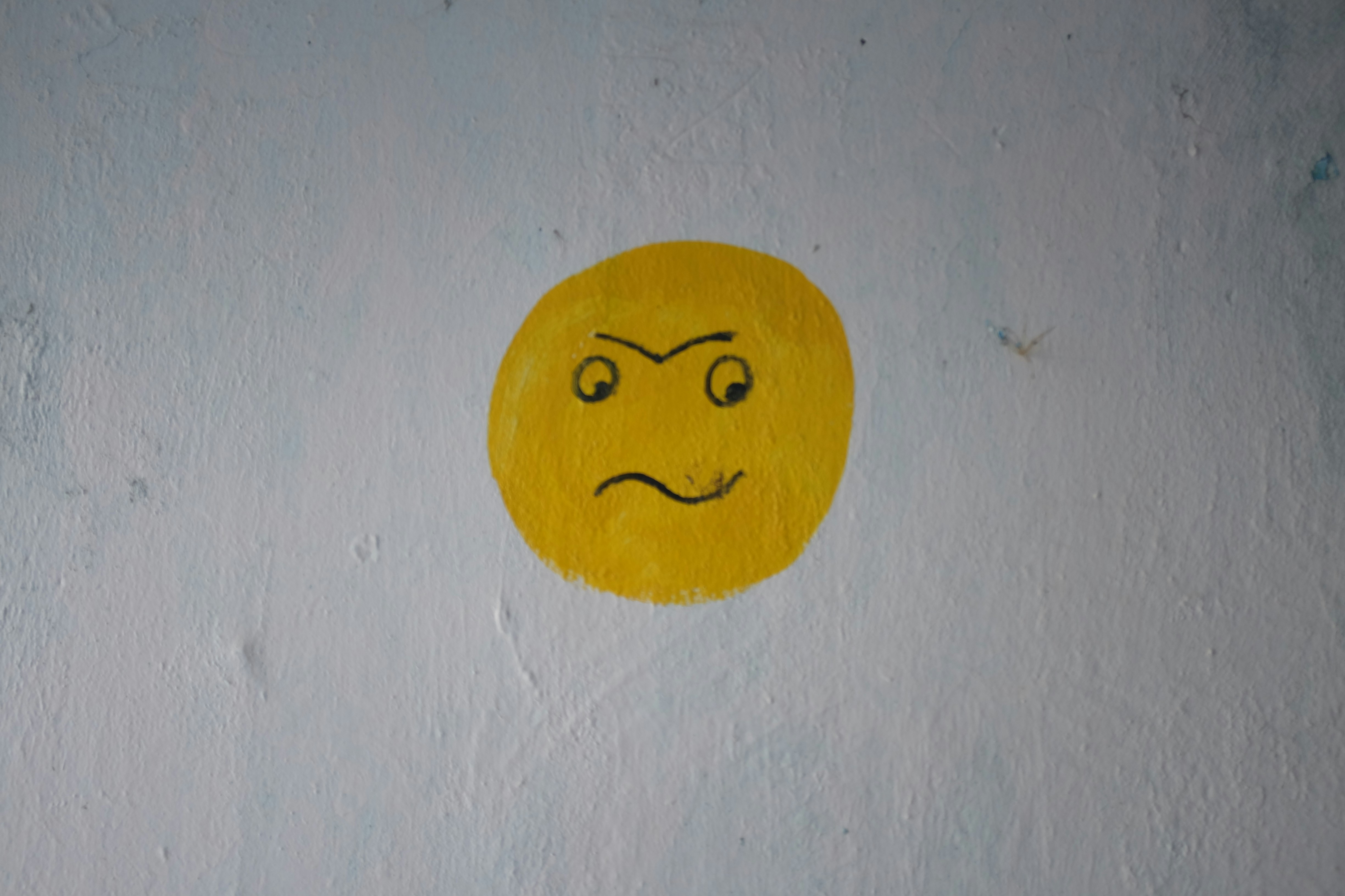 Sad emoji on a wall.